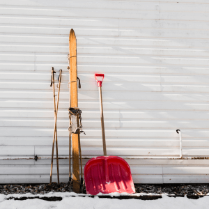 Snow gear leans against the side of the house before professional exterior painting.